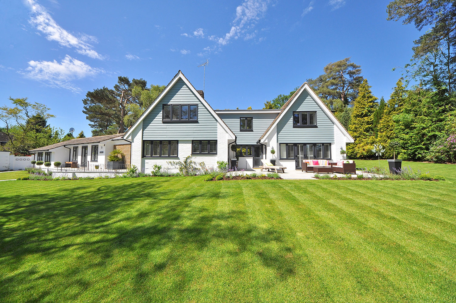 Detached white house with large, well-maintained yard.