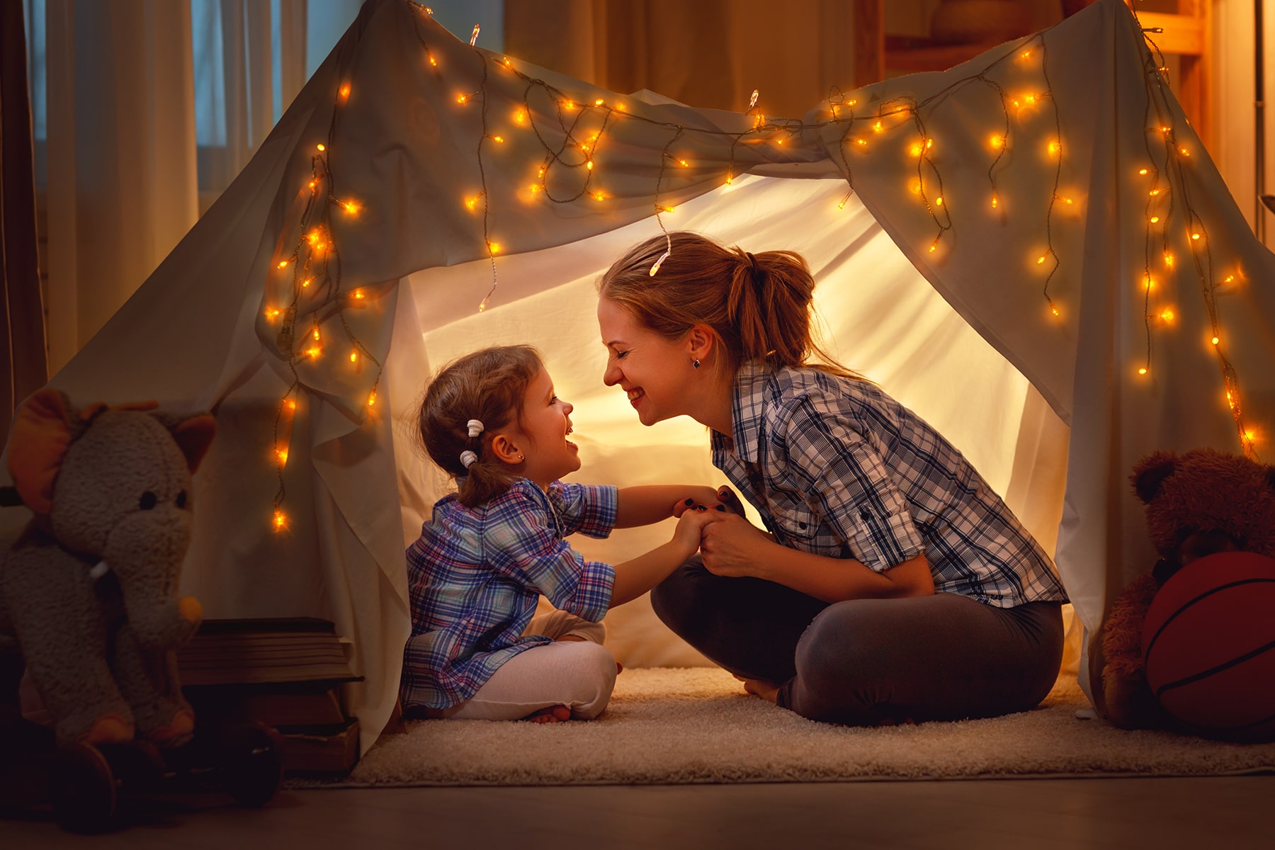 Mother and son playing inside a makeshift tent in their home.