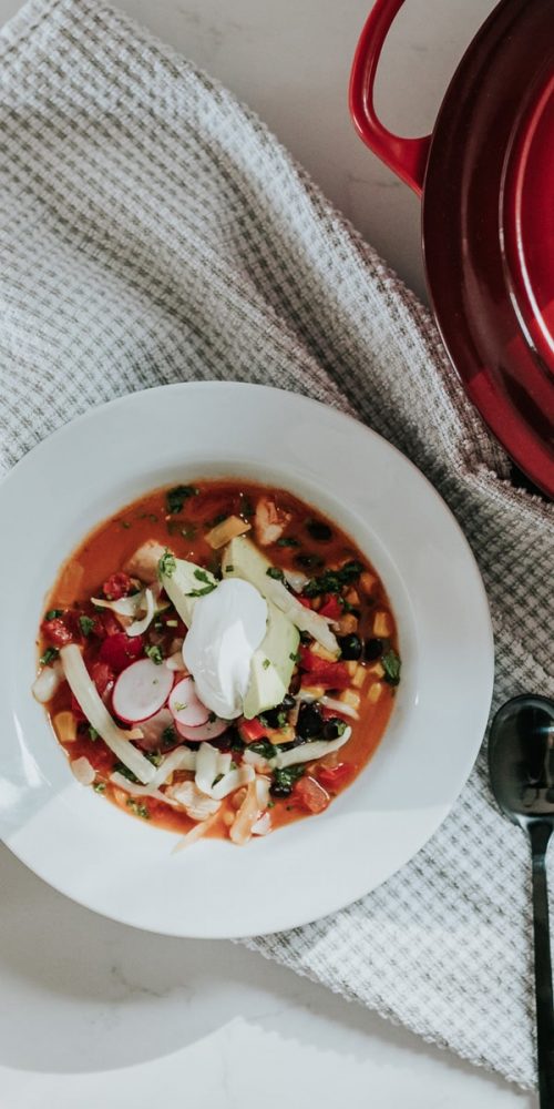 image of soup in a bowl next to a cast iron dutch oven